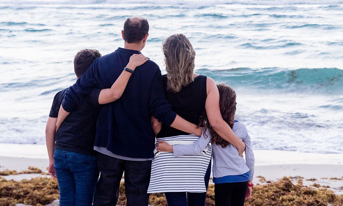 Family on the beach looking out to the ocean.